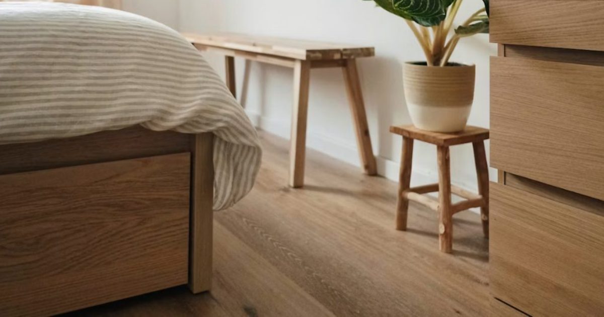 Timber-look floor beside a wooden bench, a plant and a bed with drawers